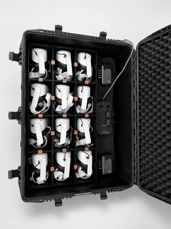 Top view of twelve headsets, with charging equipment arranged beside the bays.